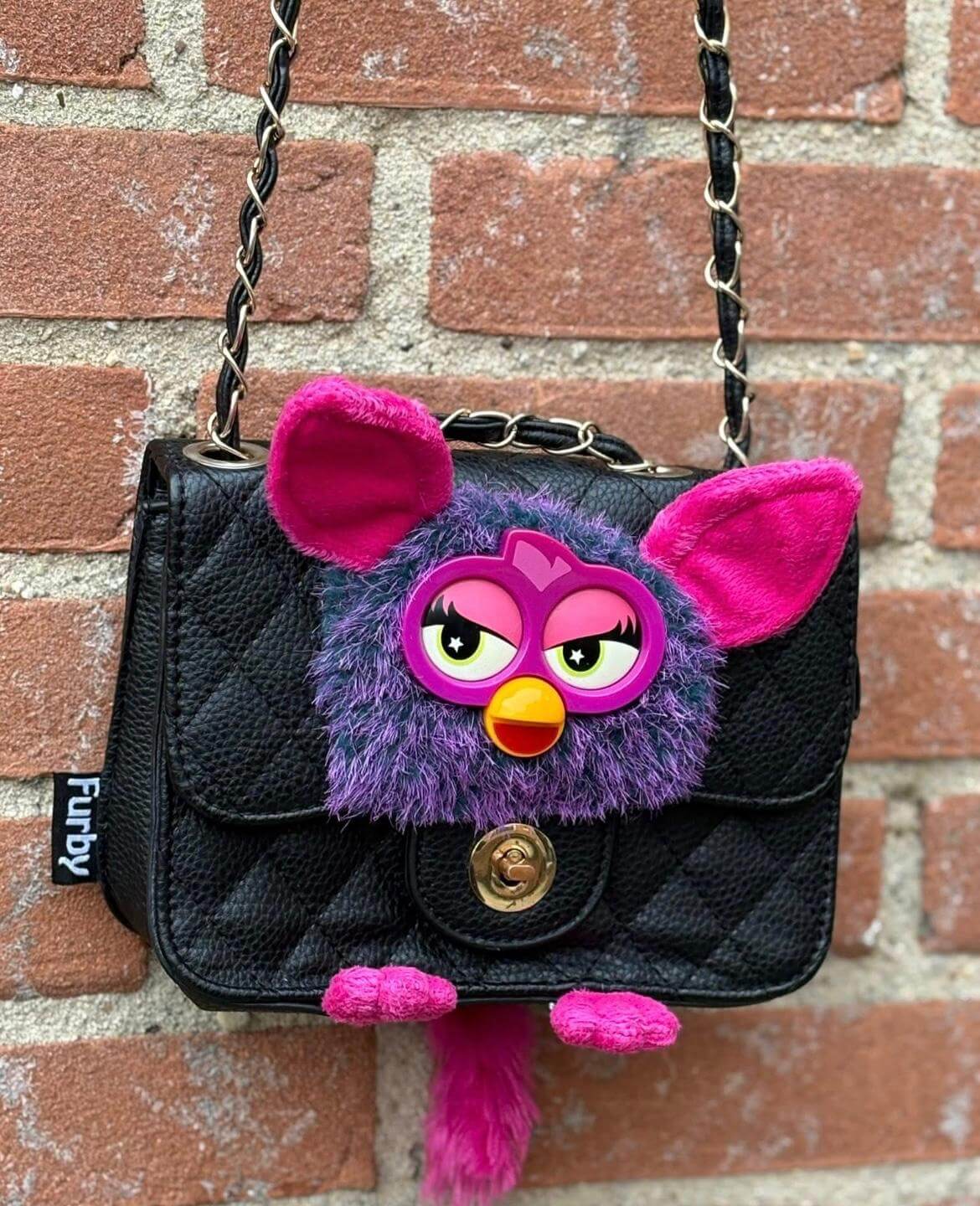 Zwarte gewatteerde handtas met een paars-roze Furby op de voorkant, handgemaakt door een lokale maker, bij FLUPS in Amersfoort